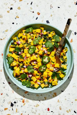 A bowl of fresh mango salsa made with diced mango, red onion, jalapeño, cilantro, and lime juice