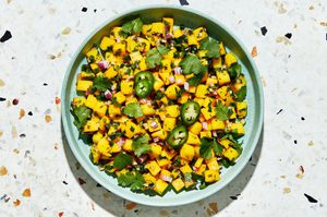 A bowl of fresh mango salsa made with diced mango, red onion, jalapeño, cilantro, and lime juice