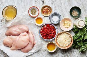 olive oil, chicken, salt, garlic, cream, chicken stock & bouillon, parmesan, sun-dried tomatoes, and spices on the counter