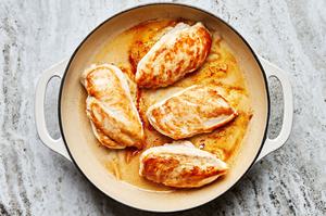 chicken breasts seasoned with salt being seared in olive oil in a skillet