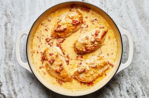 marry me chicken cooking in a skillet made with garlic, cream, parmesan, Italian seasoning and sun-dried tomatoes
