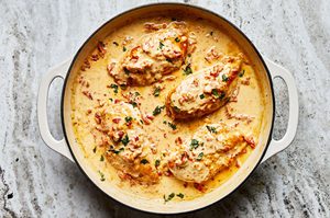 marry me chicken cooking in a skillet made with garlic, cream, parmesan, Italian seasoning and sun-dried tomatoes