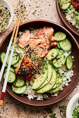 A vibrant miso salmon rice bowl with tender salmon and steamed rice topped with avocado, cucumber and furikake