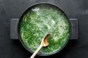 wine sauce for mussels being stirred in a pot made with butter, shallot, garlic, white wine, parsley and lemon juice