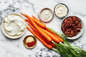Carrots, Pecans, Cream cheese, Mayo, Ranch seasoning packet, Garlic powder and Cayenne in bowls on the counter to make dip