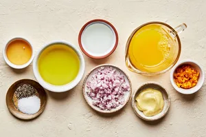 vinegar, olive oil, orange juice & zest, shallot, dijon, salt & pepper in bowls to make orange vinaigrette