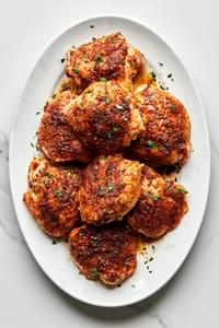 oven baked chicken thighs on a serving platter seasoned with olive oil, salt, garlic powder, onion powder, paprika, & pepper