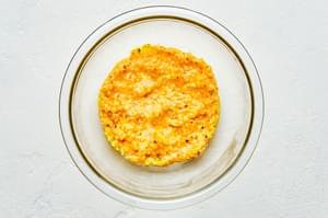 beaten egg yolks, Pecorino Romano and black pepper stirred together in a glass bowl for homemade pasta carbonara sauce