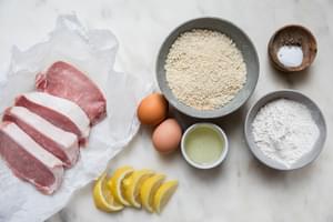 boneless pork chops, salt, black pepper, flour, eggs, plain breadcrumbs, vegetable oil, Lemon wedges in bowls on the counter
