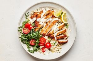 pork milanese bowls made of Skillet-Fried Pork Cutlets on top of lemon parmesan rice  and drizzled with creamy lemon dressing