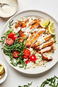 pork milanese bowls made of Skillet-Fried Pork Cutlets on top of lemon parmesan rice  and drizzled with creamy lemon dressing
