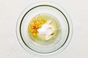 lemon zest, lemon juice, sugar, garlic, minced, salt, vinegar, mayonnaise, and olive oil in a bowl for creamy lemon dressing