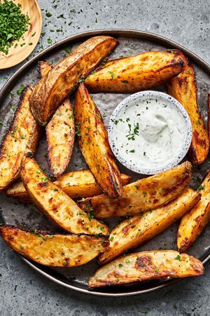 Potato Wedges seasoned with brown sugar, salt, pepper, garlic powder and paprika on a plate served with Ranch dressing