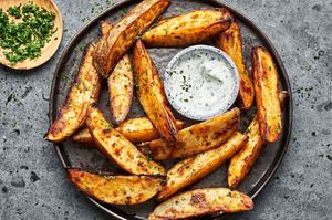 Potato Wedges seasoned with brown sugar, salt, pepper, garlic powder and paprika on a plate served with Ranch dressing