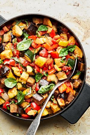 homemade ratatouille in a skillet made with eggplant, zucchini, squash, onion, garlic, thyme, tomatoes, bell peppers & basil