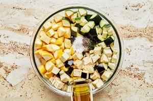 diced eggplant, zucchini & squash in a bowl with salt, pepper, garlic powder, and olive oil