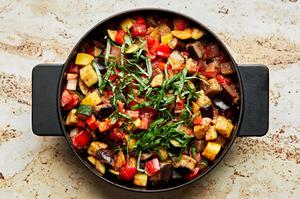 homemade ratatouille in a skillet made with eggplant, zucchini, squash, onion, garlic, thyme, tomatoes, bell peppers & basil