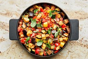 homemade ratatouille in a skillet made with eggplant, zucchini, squash, onion, garlic, thyme, tomatoes, bell peppers & basil
