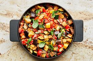 homemade ratatouille in a skillet made with eggplant, zucchini, squash, onion, garlic, thyme, tomatoes, bell peppers & basil
