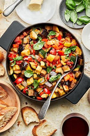 homemade ratatouille in a skillet made with eggplant, zucchini, squash, onion, garlic, thyme, tomatoes, bell peppers & basil