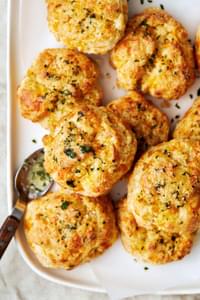 homemade red lobster cheddar bay biscuits topped with melted butter and spices (salt, onion, garlic and parsley) on a plate