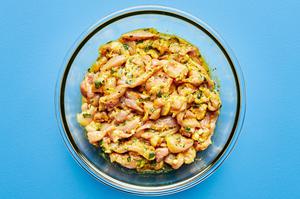chicken marinating in garlic powder, onion powder, turmeric, ginger, cilantro, lime juice, honey, olive oil, salt and pepper