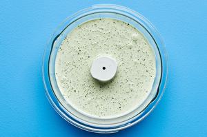 cilantro ranch in a food processor made with buttermilk, mayo, sour cream, cilantro, jalapeño, onion & garlic powders & salt