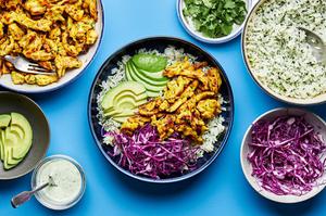 ingredients to assemble rice bowls on the counter including turmeric ginger chicken, cilantro-lime rice and cilantro ranch