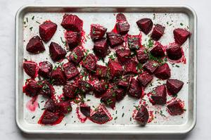 roasted beets on a baking sheet tossed with white vinegar, fresh herbs and pepper