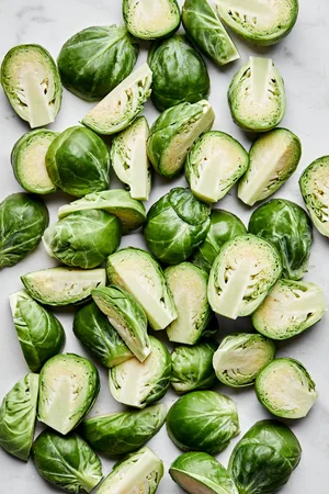 raw brussels sprouts with their ends cut off and cut in half ready to be seasoned and roasted