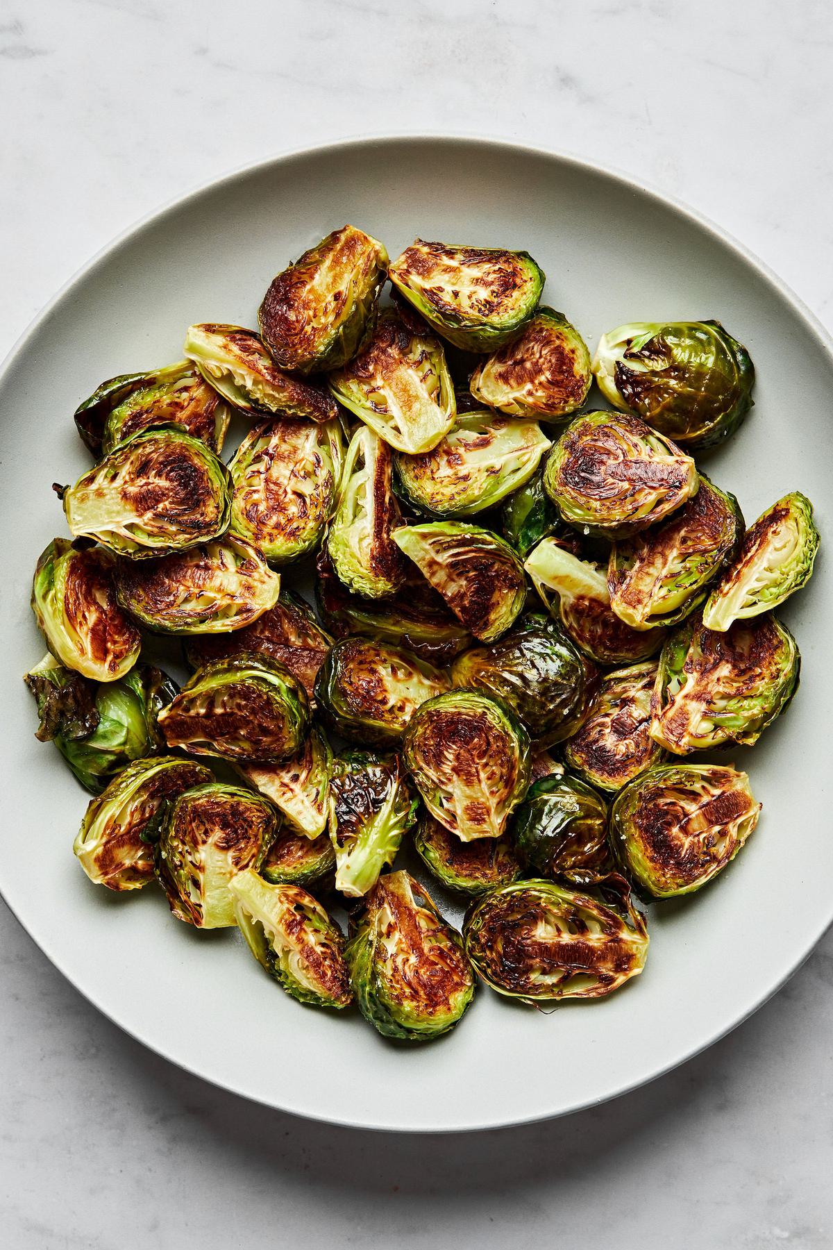 roasted brussels sprouts in a serving bowl seasoned with olive oil and salt
