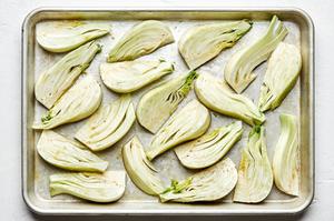 raw fennel sliced on a baking sheet tossed with olive oil, salt, garlic powder and pepper