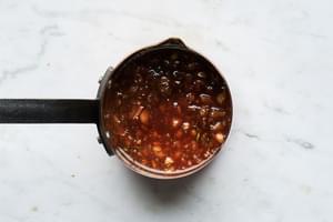 homemade honey-sweetened, herb-and-orange glaze in a small sauce pan for roasted garlic honey baked ham