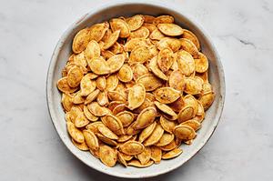 a bowl of roasted pumpkins seeds seasoned with salt, garlic powder, onion powder, paprika, mustard powder and pepper