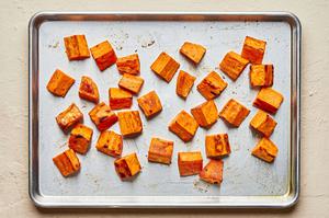 roasted sweet potatoes on a baking sheet seasoned with olive oil, salt, garlic powder & pepper