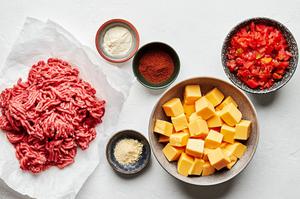 ground beef, chili powder, onion powder, garlic powder, velvet cheese, and canned rotel tomatoes in bowls to make rotel dip