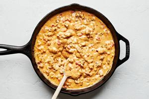 rotel dip being stirred in a skillet made with beef, chili powder, onion powder, garlic powder, velveeta and rotel tomatoes