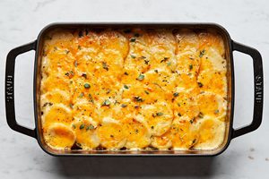 homemade scalloped potatoes in a casserole dish made with milk, cheese, thyme, and nutmeg