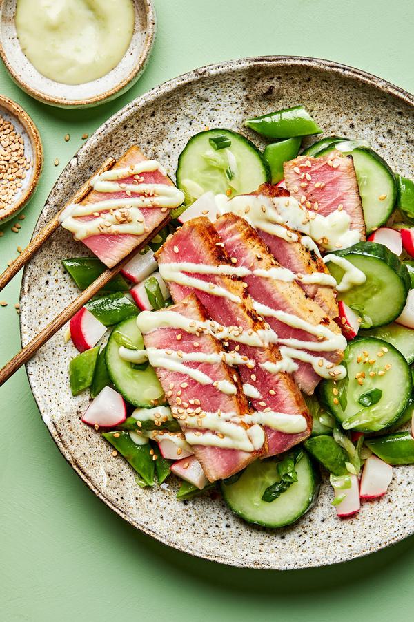 seared ahi tuna served on top of cucumber salad drizzled with  wasabi mayo and sprinkled with sesame seeds