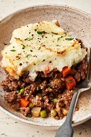 Shepherd’s pie in a bowl, topped with golden mashed potatoes and baked until lightly browned