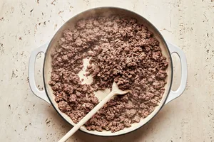 ground beef being cooked in a skillet with olive oil to use for shepherd's pie