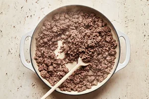 ground beef being cooked in a skillet with olive oil to use for shepherd's pie
