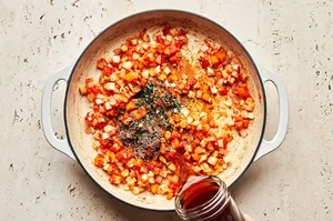 a savory filling for shepherd's pie being cooked in a skillet with beef, peas, vegetables, tomato paste and spices
