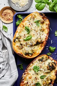 Spaghetti Squash with Creamed Spinach and Chicken on a baking sheet topped with parmesan and basil