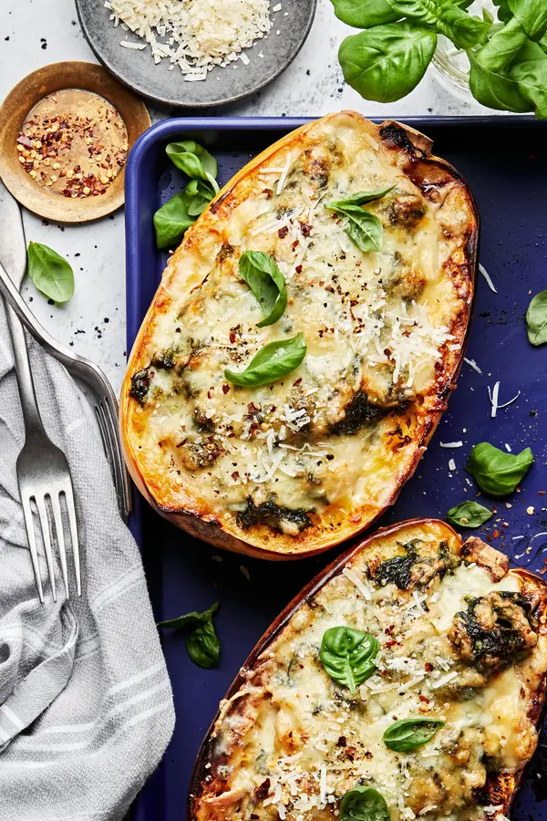 Spaghetti Squash with Creamed Spinach and Chicken on a baking sheet topped with parmesan and basil