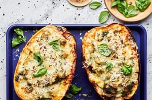Spaghetti Squash with Creamed Spinach and Chicken topped with parmesan and fresh basil on a baking sheet
