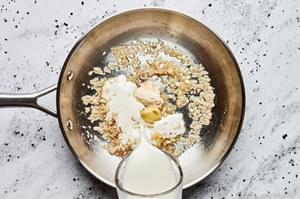 butter, shallot and garlic being cooked in a skillet