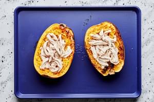 roasted spaghetti squash filled with chicken and mozzarella ready to be baked in the oven