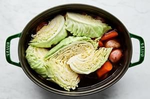 Beer, Beef stock and water in a pot, with potatoes, carrots and cabbage