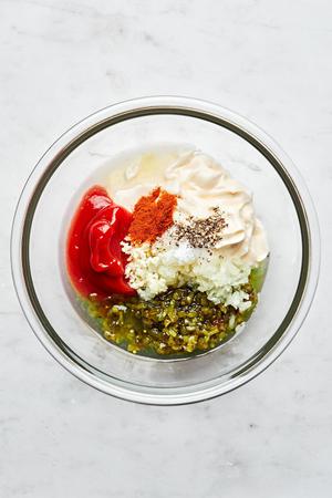 mayonnaise, ketchup, relish, paprika, lemon juice, onion, garlic, salt and pepper in a bowl for thousand island dressing